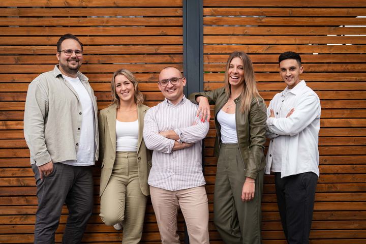Business-Team vor einer Holzfassade